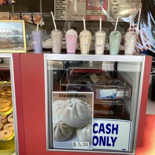a cash only sign in the window of a donut shop
