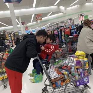 a man pushing a shopping cart with a child in it