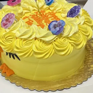 a yellow cake decorated with flowers
