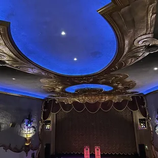 a stage with a blue ceiling and a stage with a red curtain