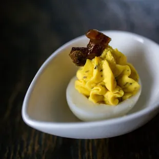 a deviled egg with bacon on top