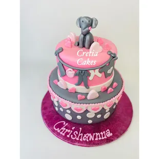 a pink and grey cake with an elephant on top