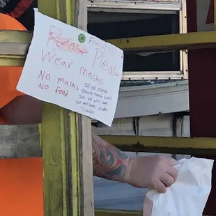 a person holding a sign in front of a window