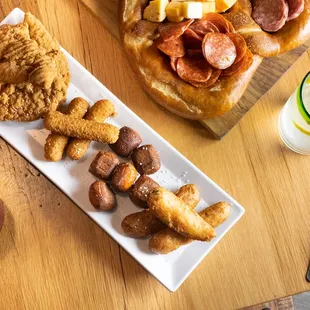A sampling of Mozzarella Sticks* Pretzel Bites* Chicken Strips and fried pickles served with sides of beer cheese * sauce s