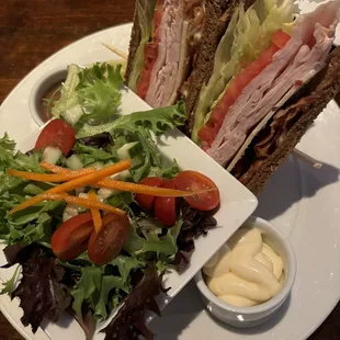 Turkey club sandwich with a side salad