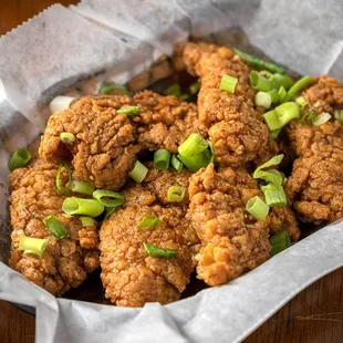 a basket of fried chicken with green onions