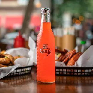 a bottle of orange soda sitting on a table