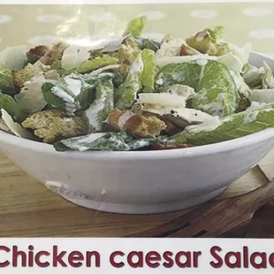 chicken caesar salad in a white bowl