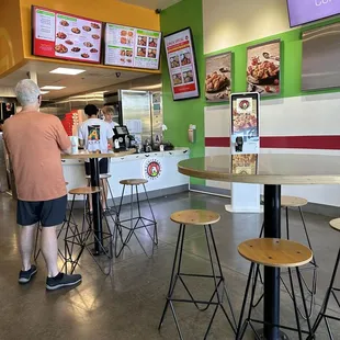  a man standing at a counter in a fast food restaurant