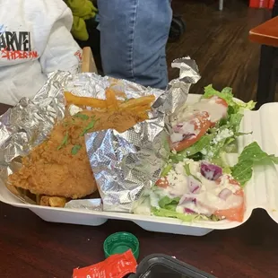 a tray of fried chicken and a salad