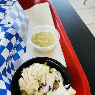 ows a bowl of coleslaw with a side of mustard