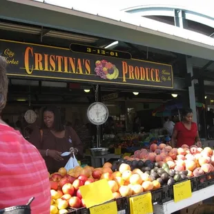 a man standing in front of a fruit stand