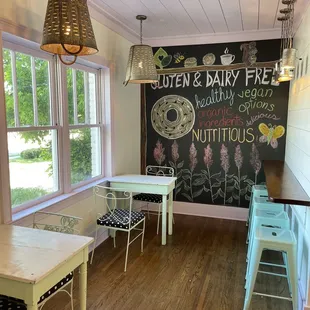 a table and chairs in front of a chalkboard