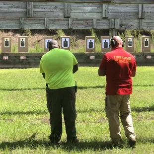 Frank one on one with a student helping him understand the proper way to stand and sight in the target with his AR15