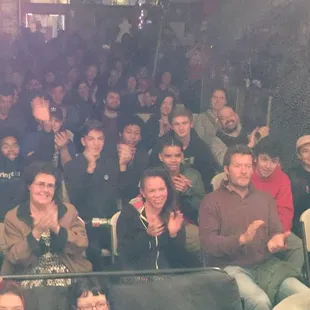 a large group of people sitting and standing