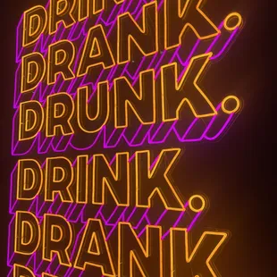 a neon sign that reads drink drank drunk