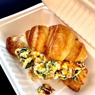 a croissant sandwich in a styrofoam container