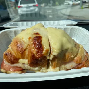 a croissant sandwich in a styrofoam container