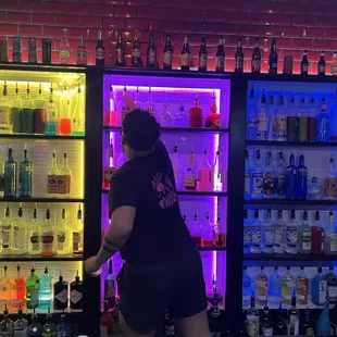 a woman standing in front of a display of liquor bottles