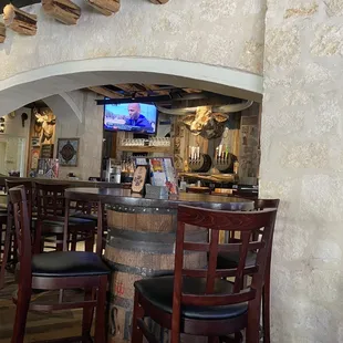 a bar with chairs and a television