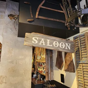 a saloon sign hanging from the ceiling