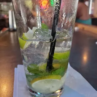 a glass of water with ice and lime slices