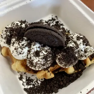 a waffle with oreo cookies and whipped cream