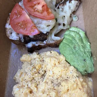The French scrabble has soft scrambled eggs, avocado, tomato, fontina, toast, and truffle oil
