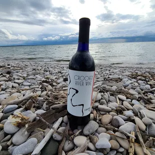 a bottle of wine on a rocky beach