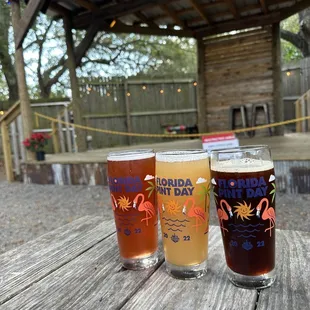 three glasses of beer on a picnic table