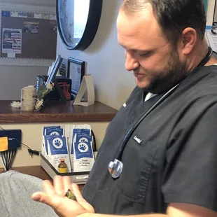 Dr. Cox examining a Hummingbird after a client brought it in with a broken wing.