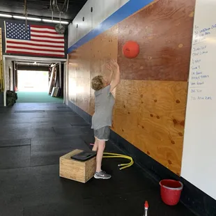 Our workouts are modifiable for all athletes. Pam is using a light ball and a box to simulate wall balls.