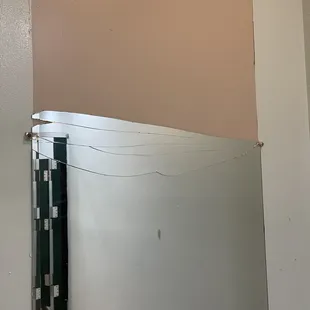 Broken mirror in the e men's room.