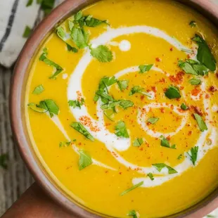 a bowl of soup with cream and garnish