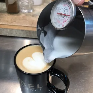 a person pouring milk into a cup