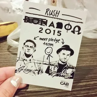 a person holding a sticker with a drawing of two men