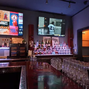 a bar with wine glasses lined up on the bar