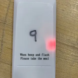 When ready, this little device will beep and show four blinking lights. Pick up your order at the left (west) side of the counter.