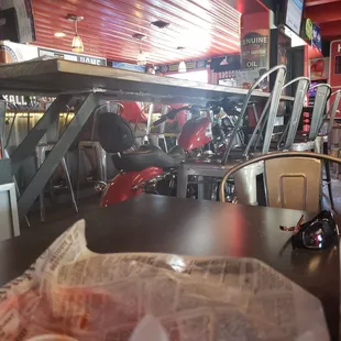 a view of a cafe with a red motorcycle parked in the background