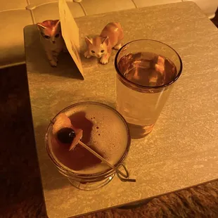 a cat and a drink on a table