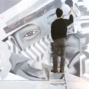 Artist Brandon Marshall paints a mural for The Moonpie Project in February 2017