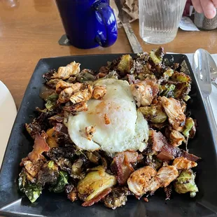 Brussel sprouts fried with bacon and grilled chicken topped with a fried egg.