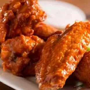 a plate of buffalo wings with celery