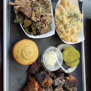 a tray of food including meat, macaroni and cheese
