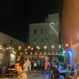 a crowd of people sitting and standing outside at night
