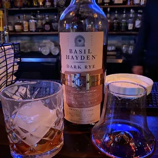 a bottle of basil hayden dark rye and two glasses of whiskey