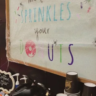 a sign that says what to drink sprinkles and donuts