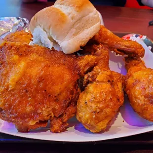 a plate of fried chicken and a roll