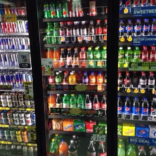 a refrigerated display of sodas and soft drinks
