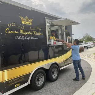 a woman standing in front of a food truck